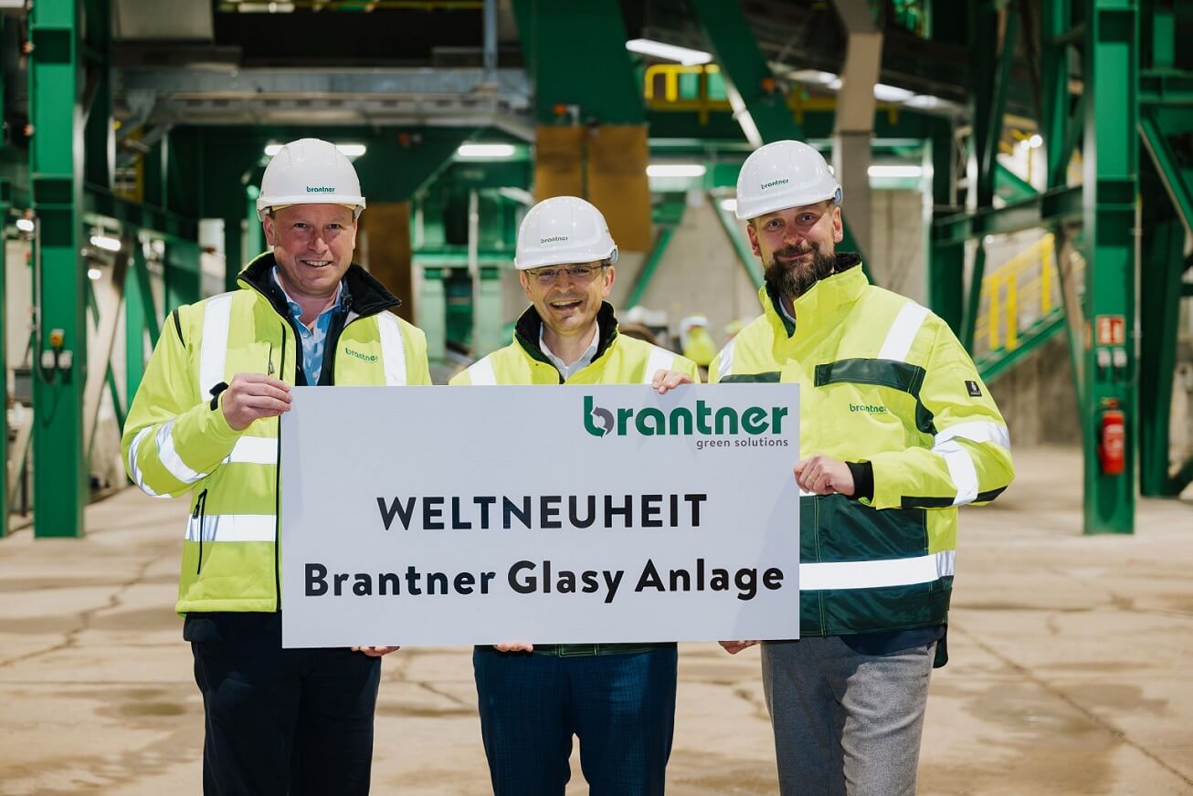 Drei Personen halten ein Schild zur Eröffnung der Brantner Glasy Anlage